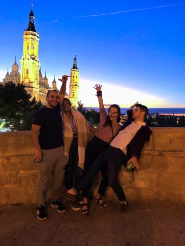Vanessa and friends posing in front of an illuminated castle in Spain