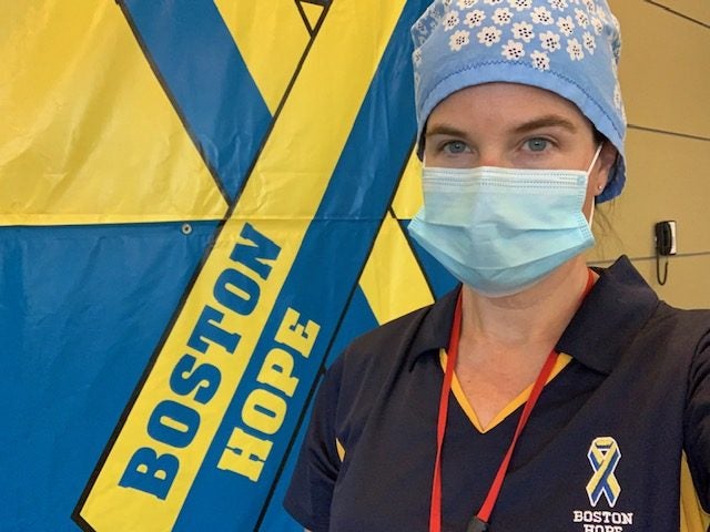 Kim Daly wearing PPE in front of a Boston Hope flag