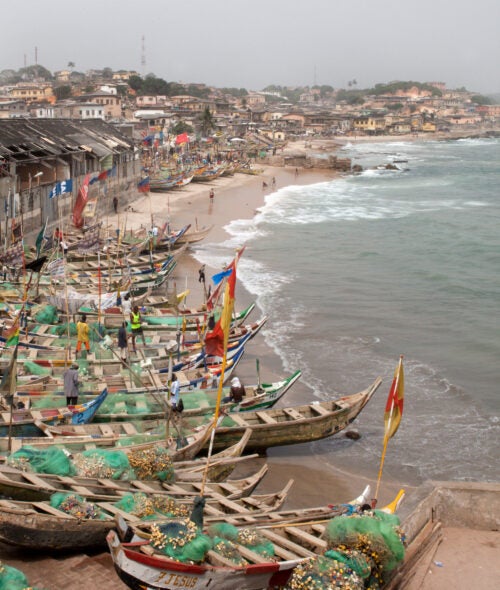 Brightly colored fishing canoes on the beach in Cape Coast, Ghana