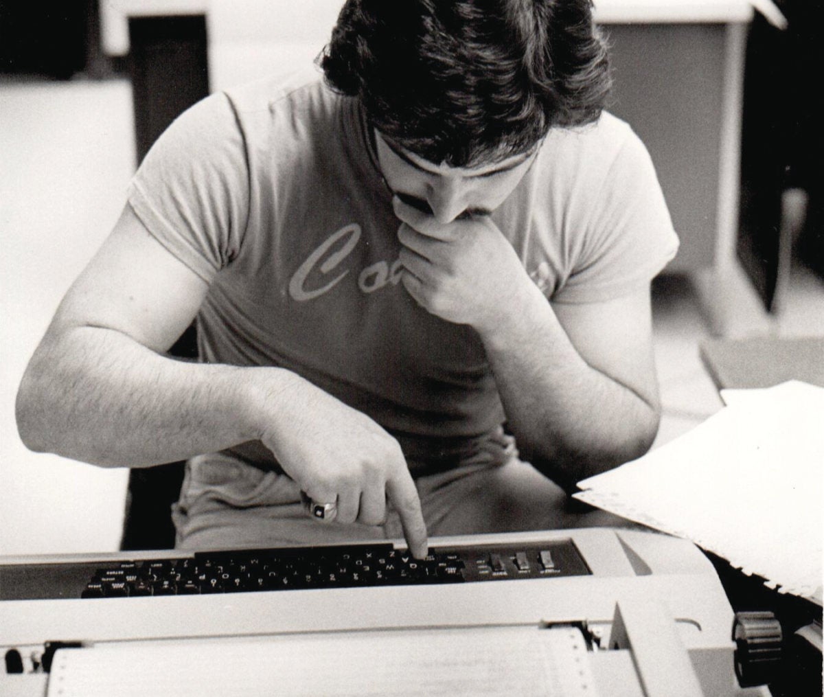 A student bends over a vintage word processor