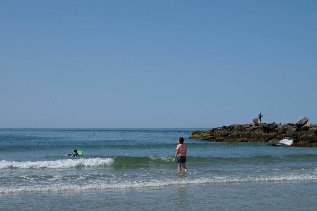 Barbara Caron, Editor-in-Chief, paddling over the calm waves at Fenway Beach in Westerly, R.I.