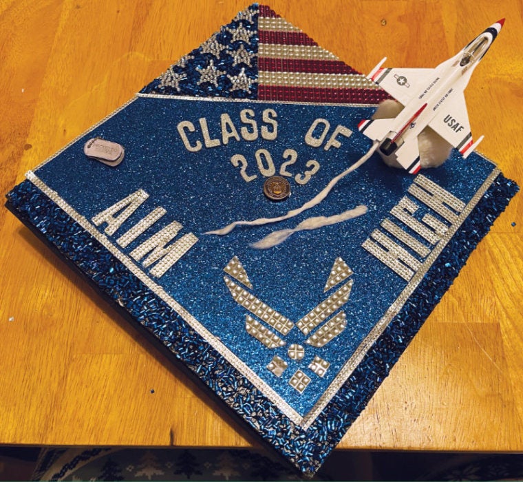 A graduation cap decorated by Kevin Ramos showing an Air Force jet and the words, "aim high"