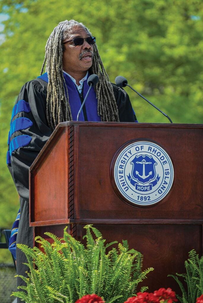 Earl N. Smith III '89 - speaking outdoors at a podium in graduation robes