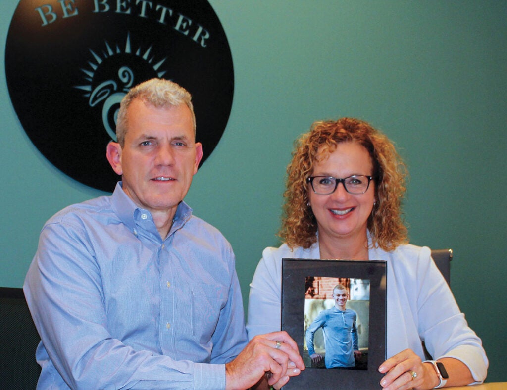 Steve and Jill Miskelley holding a photograph of their late son, Ian