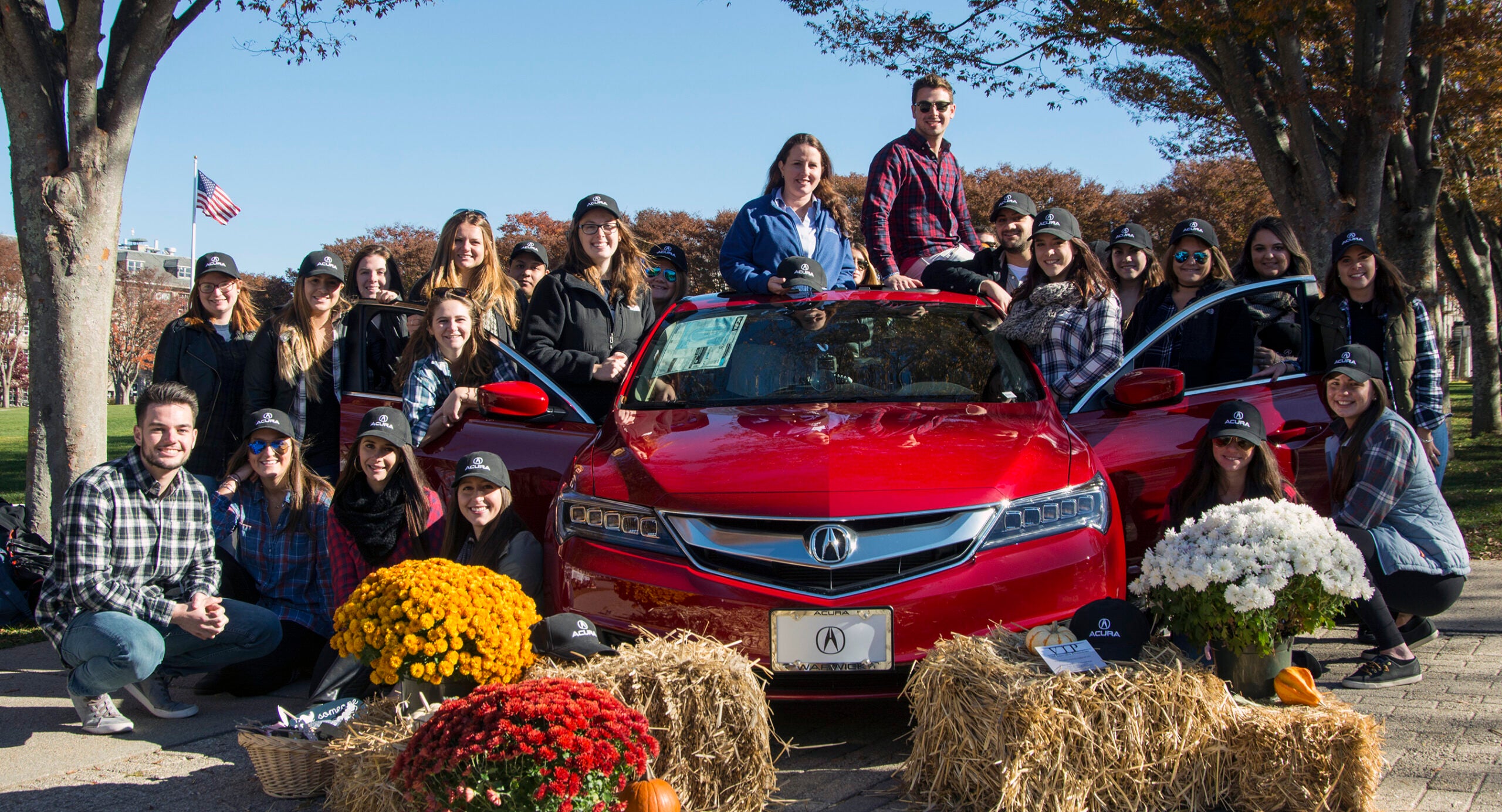 All Aboard: Assistant Professor of Marketing Christy Ashley (center) smiles as her students gather around the product of their marketing endeavors. URI photograph by Nora Lewis.