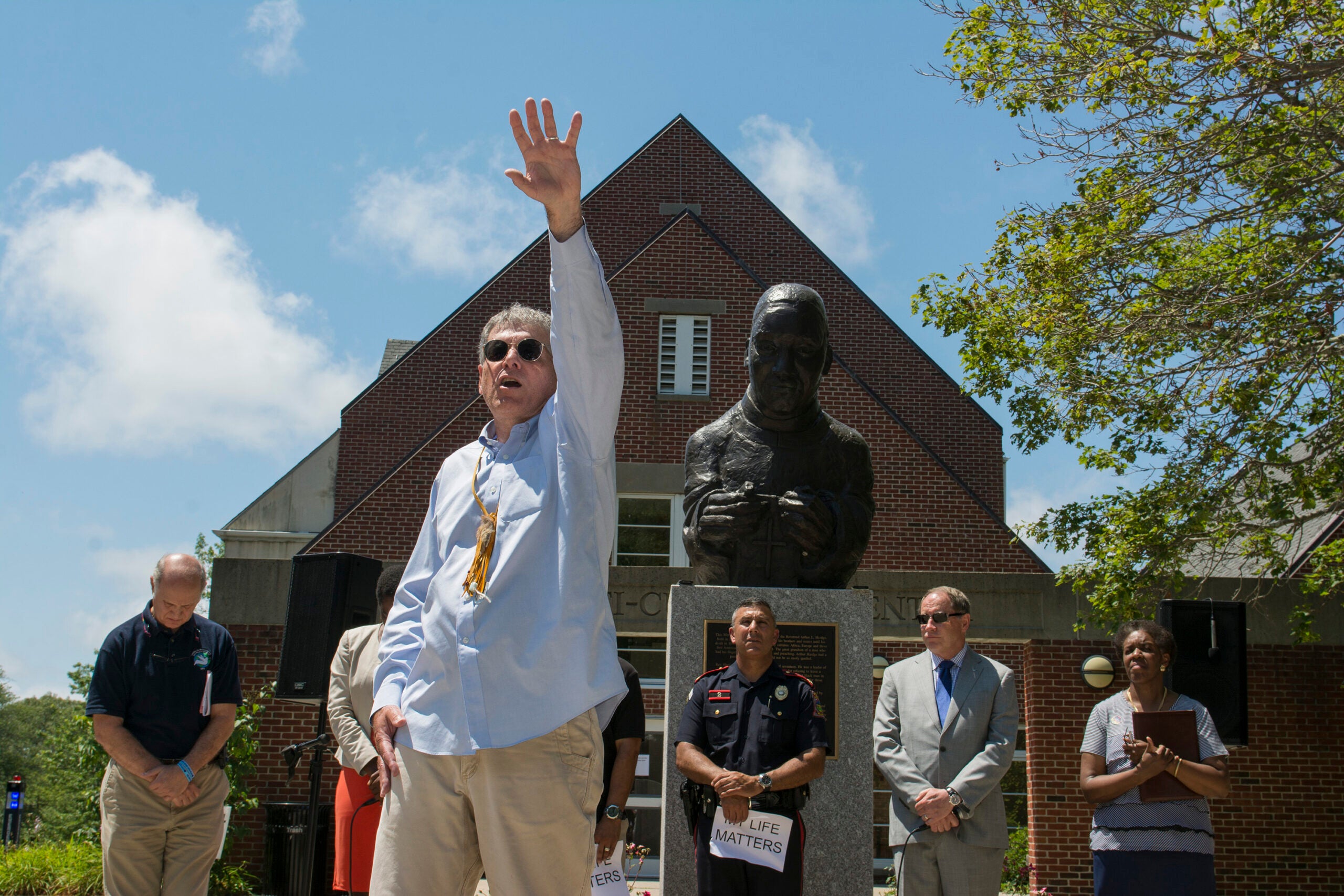 Frank Forleo, assistant director of Talent Development, exhorts the gathering Wednesday in front of the Multicultural Student Services Center. URI photo by Nora Lewis