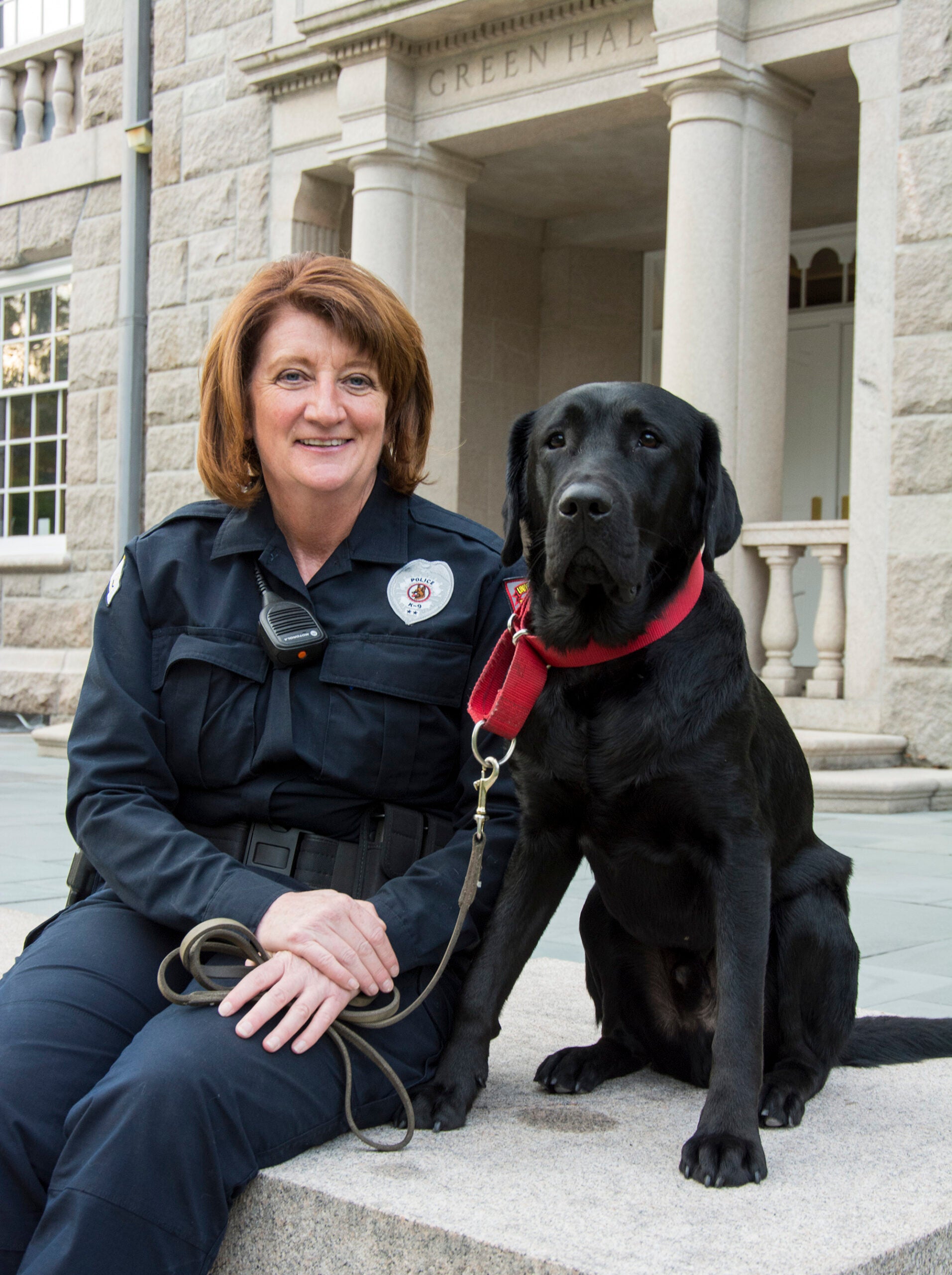 URI Police Sgt. Erica Vieira of Richmond and her new partner, Officer Figaro, take a break outside Green Hall. URI photo by Nora Lewis
