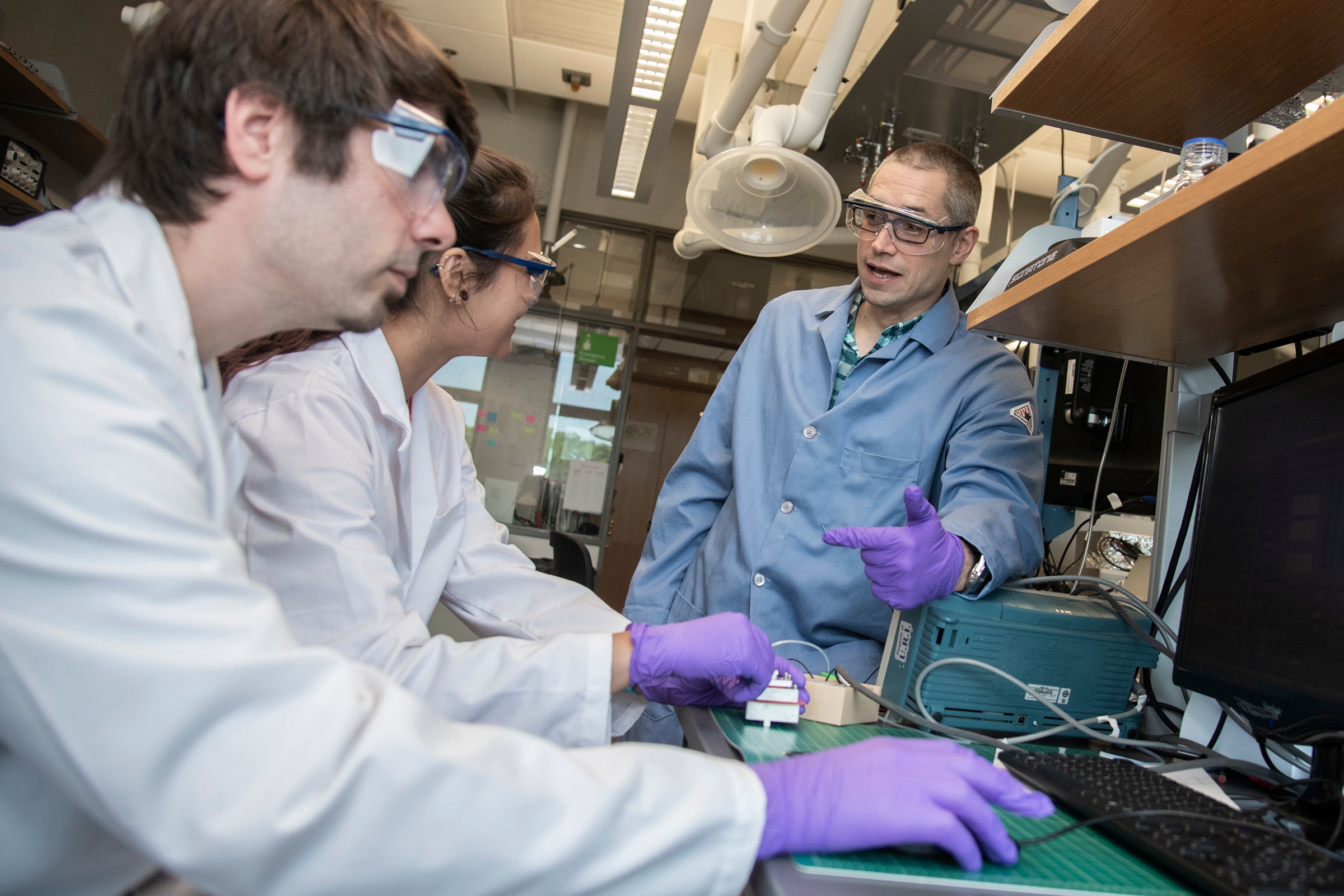 Jason Dwyer, right, talks with doctoral student James Hagan and Cranston high school student Anna Khabaeva