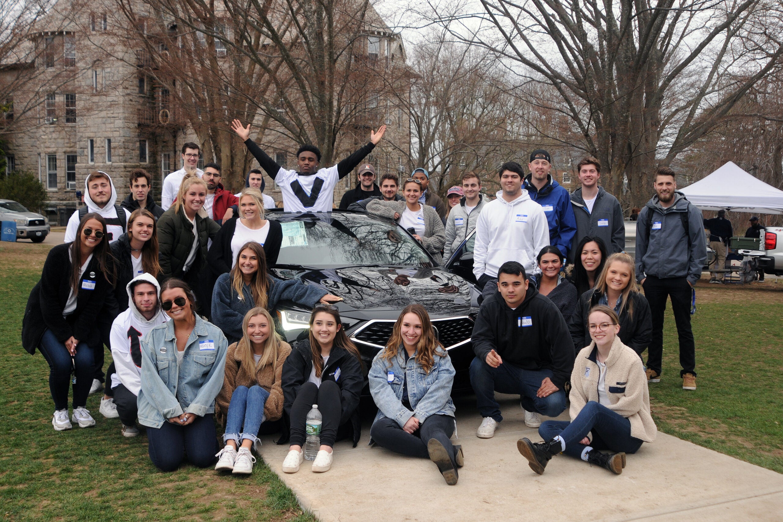 Capstone marketing class pose around a 2019 Acura