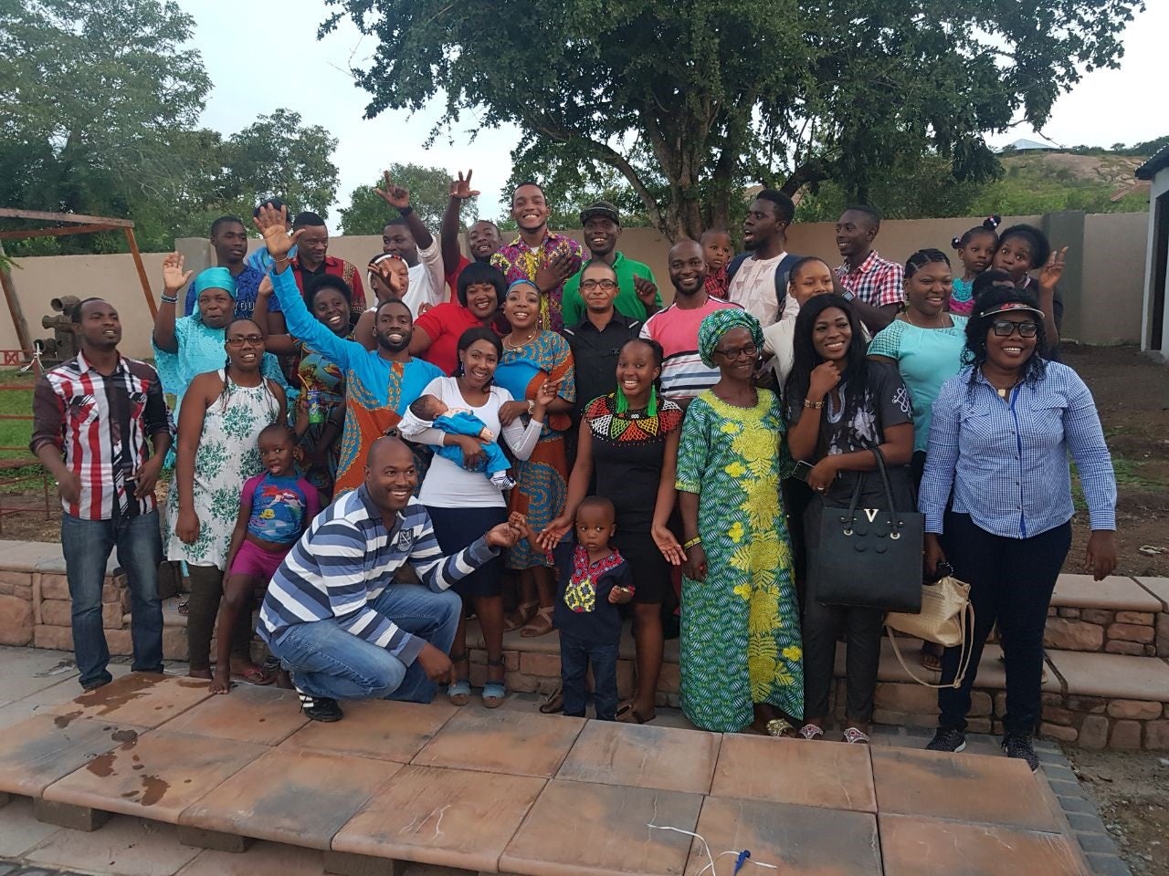URI graduate and Peace Corps volunteer Joseph Gomes, center, in black shirt and glasses, gathers for a photo with villagers in South Africa. (Photo courtesy of Joseph Gomes)