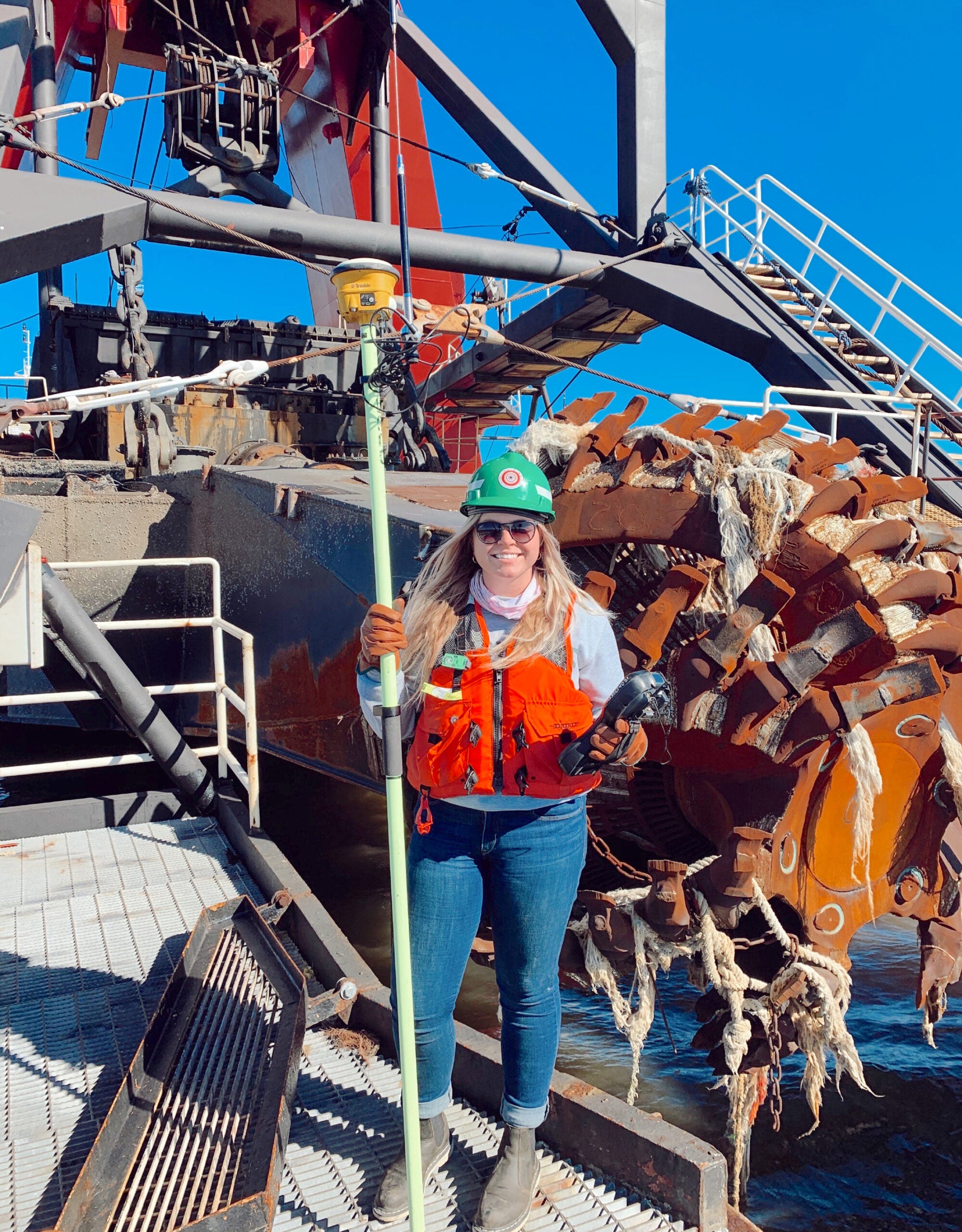 URI junior Faith Leonard holds survey equipment aboard a cutter dredge boat. Photo courtesy of Great Lakes Dredge & Dock Corporation