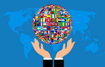 illustration: hands holding a globe of flags from around the world