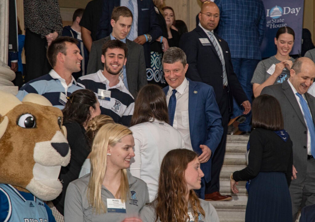 URI President Marc Parlange surrounded by attendees of URI Day, including URI mascot Rhody the Ram