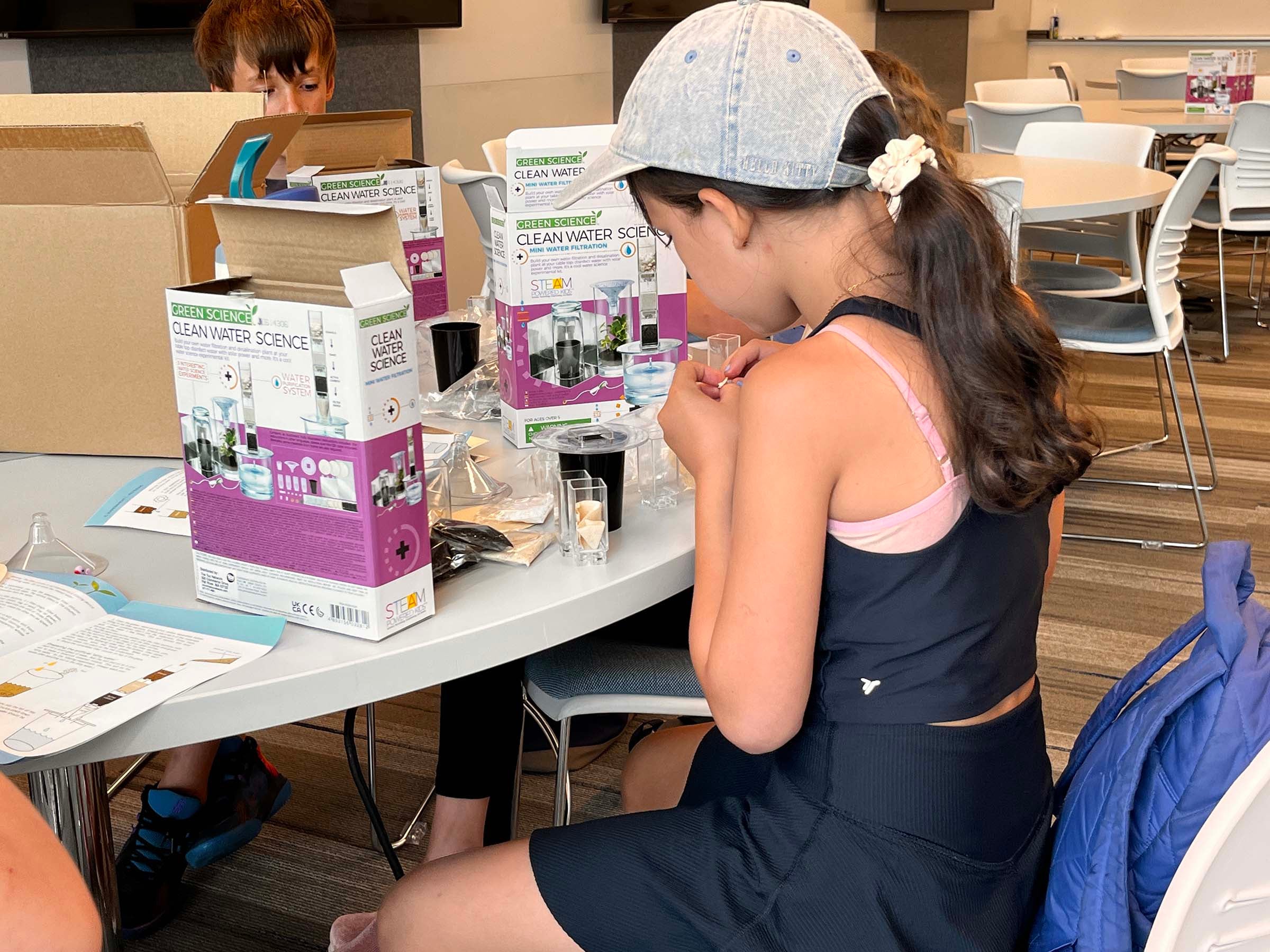 A child works with a mini water filtration kit