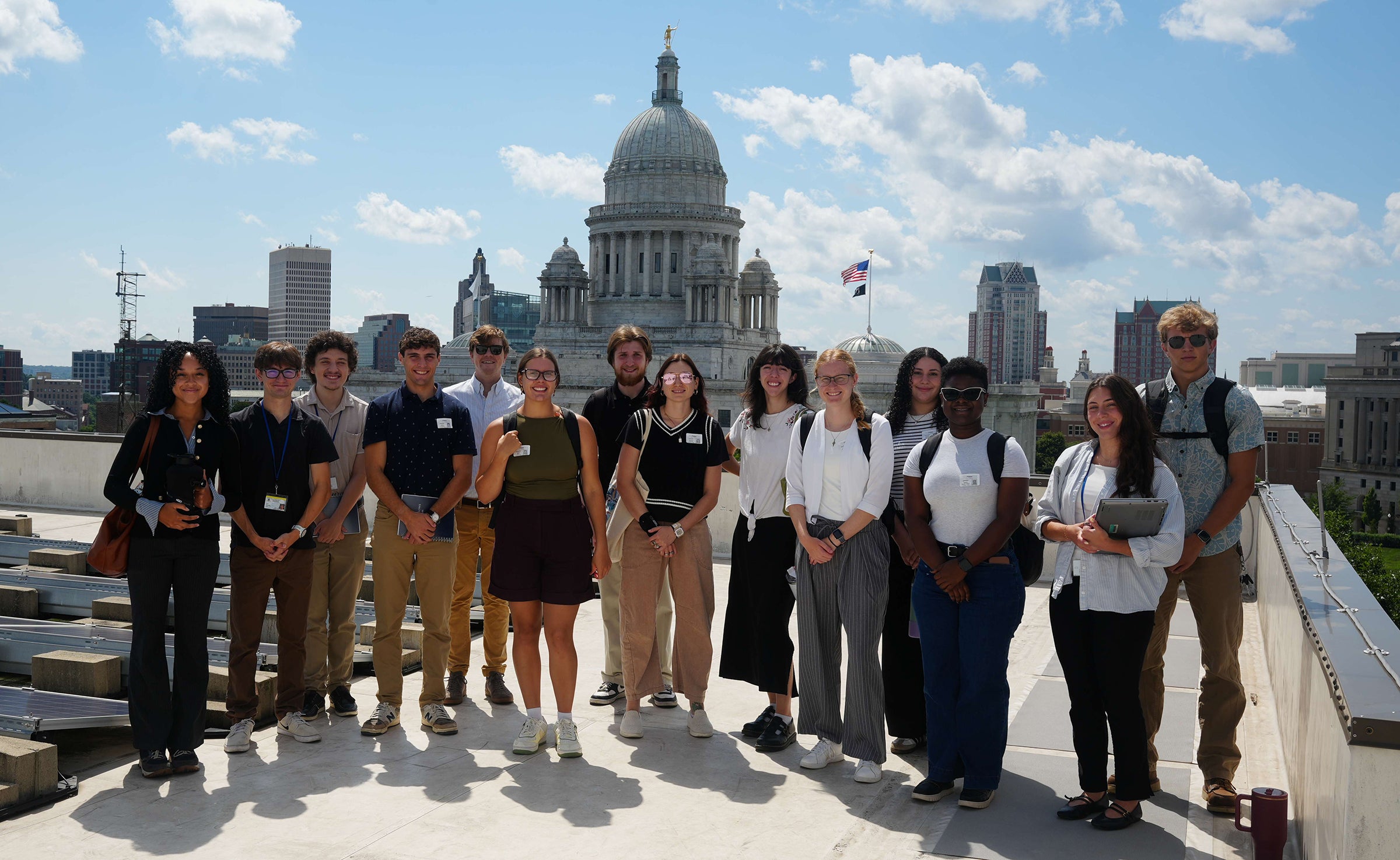 A group of Cooperative Extension Fellows stand in front of the RI state capital building