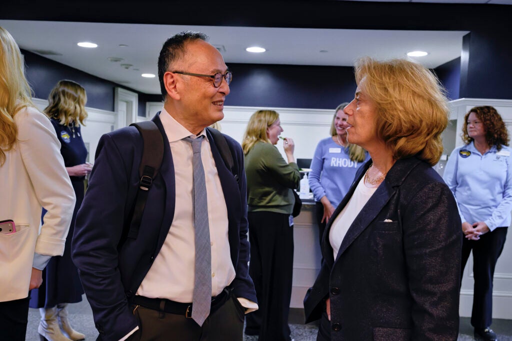 Gerald Chan, left, speaks with URI Board of Trustees Chair Margo Cook