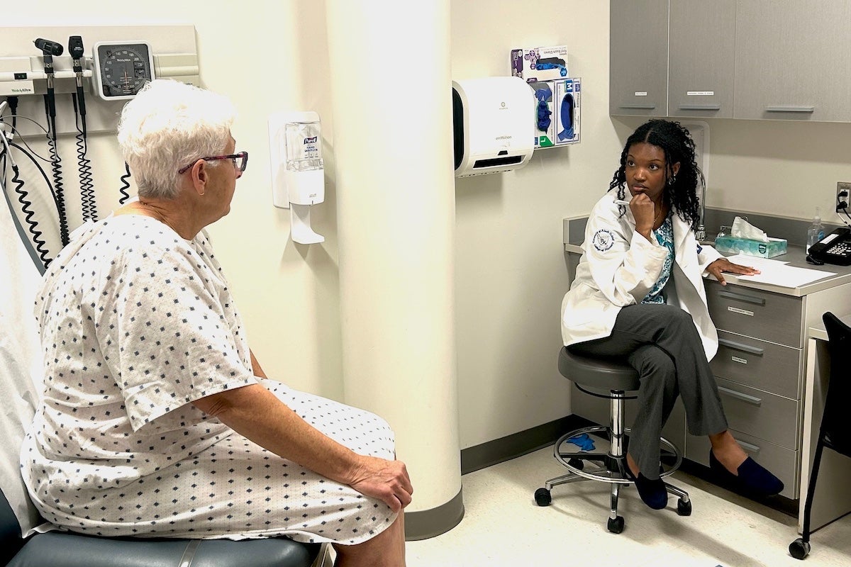 student Kai Reddie interviews a simulated patient