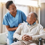 nurse helping man in wheelchair