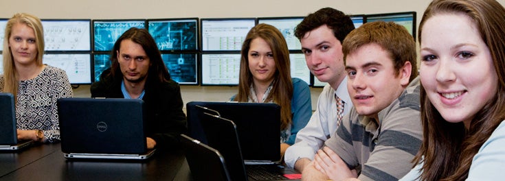 Students in URI's Cyber Security programs sitting with computers in the cybersecurity lab