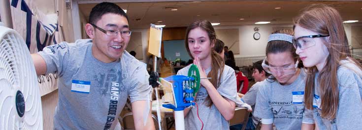 URI student Jimmy Li working with local middle school students to build a wind turbine
