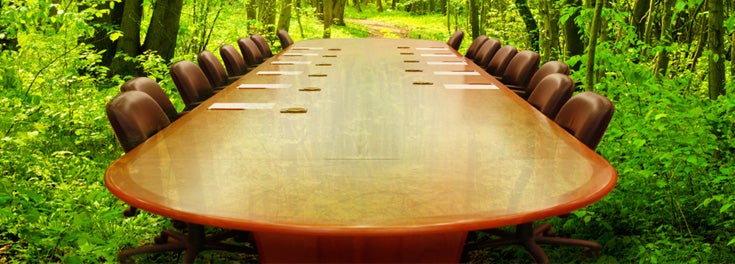 Oval boardroom table and chairs in the middle of a forest Oval boardroom table and chairs in the middle of a forest