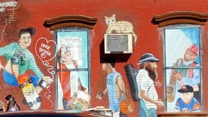 Red brick building with painted images of people in the neighborhood