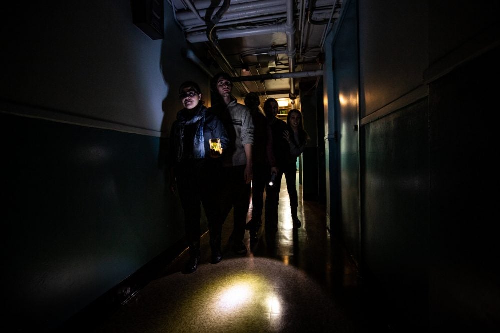 five students explore a dark hallway