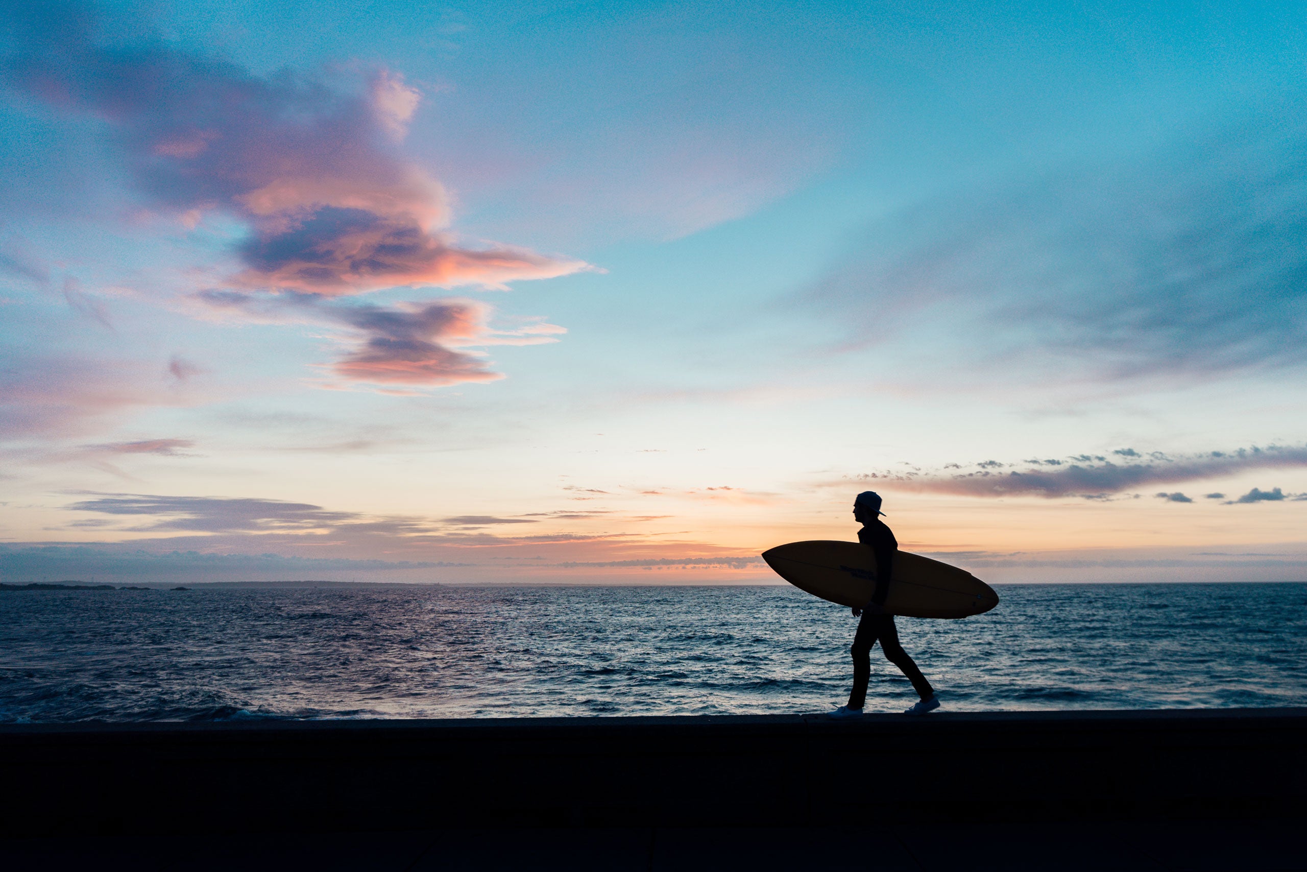 Surfer walking along the beach