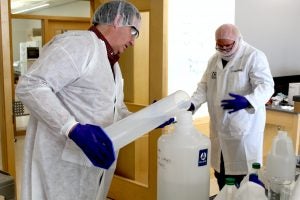 Charles McGovernand Saleh Allababidi prepare a batch of hand sanitizer
