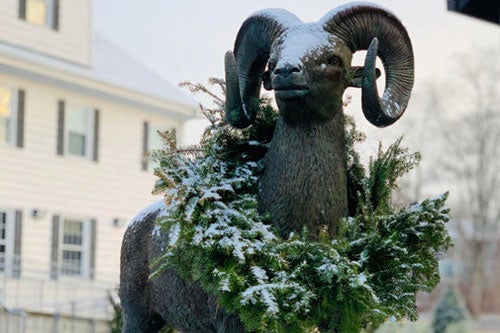 Ram statue in front of Welcome Center wearing a snowy holiday wreath