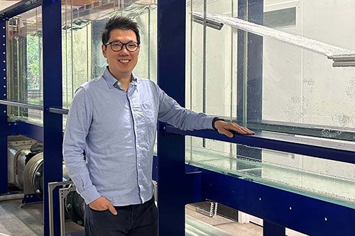Ocean engineering professor Che-Wei Chang poses in front of URI’s water flume