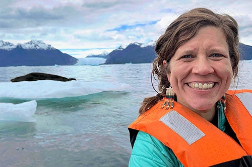 Professor Sarah Kienle with a leopard seal resting on ice in Patagonia, Chile