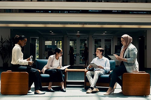 College of Business students sitting inside Ballentine Hall foyer space